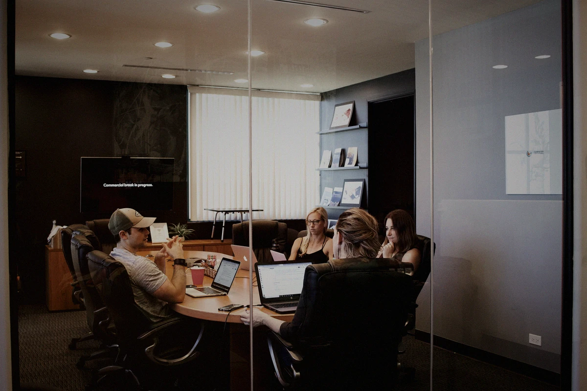 An embedded mixed team speaking directly inside a working office